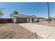 Home featuring a gray garage door, long driveway, and low maintenance desert landscaping at 343 W Santa Cruz Dr, Tempe, AZ 85282