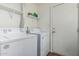 Bright laundry room with white washer and dryer and convenient overhead shelving at 343 W Santa Cruz Dr, Tempe, AZ 85282