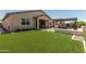 Lush backyard with artificial grass and a built-in fire pit, creating an oasis for relaxation and entertainment at 3948 E Caitlin Dr, San Tan Valley, AZ 85140