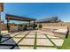 Expansive backyard featuring a covered hot tub, fire pit and decorative turf at 3948 E Caitlin Dr, San Tan Valley, AZ 85140