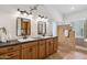 Elegant primary bathroom featuring double sinks, a black countertop, and a walk-in shower with glass blocks at 4146 N Lomond --, Mesa, AZ 85215