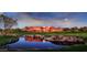 Picturesque view of a red clubhouse with a pond in the foreground, under a beautiful evening sky at 4146 N Lomond --, Mesa, AZ 85215