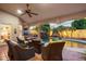 Relaxing covered patio area overlooking the pool and rock waterfall with comfortable seating and ceiling fan at 4146 N Lomond --, Mesa, AZ 85215