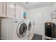 Laundry room with full-sized white washer and dryer, cabinets and rear exit at 4146 N Lomond --, Mesa, AZ 85215