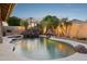 Stunning pool area with rock waterfall, lush palm trees, and ambient lighting creates a resort-like experience at 4146 N Lomond --, Mesa, AZ 85215