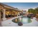 Backyard pool featuring a rock waterfall, covered patio, and lush landscaping, ideal for entertaining at 4146 N Lomond --, Mesa, AZ 85215