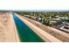An aerial view showcases a neighborhood adjacent to a canal, with lush green trees and shrubbery visible at 4379 E Rosemonte Dr, Phoenix, AZ 85050