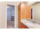 Bathroom featuring granite countertops, light wood cabinetry, and a view to the connected bedroom at 4379 E Rosemonte Dr, Phoenix, AZ 85050