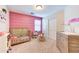 Cozy bedroom with a pink accent wall, wood floors, and plenty of space for fun and play at 4379 E Rosemonte Dr, Phoenix, AZ 85050
