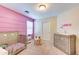 Charming bedroom featuring a pink accent wall, light wood furniture, and plush carpet flooring at 4379 E Rosemonte Dr, Phoenix, AZ 85050