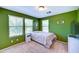 Bedroom featuring green walls, carpet, and three windows for ample natural light at 4379 E Rosemonte Dr, Phoenix, AZ 85050