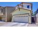 Attached two-car garage with white door and upper windows on a home with yellow horizontal siding at 4379 E Rosemonte Dr, Phoenix, AZ 85050