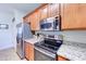 Elegant kitchen with wood cabinetry, granite countertops, and stainless steel appliances, blending style and functionality at 4379 E Rosemonte Dr, Phoenix, AZ 85050