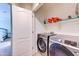 Efficient laundry room featuring a side-by-side washer and dryer with additional shelving for storage at 4379 E Rosemonte Dr, Phoenix, AZ 85050