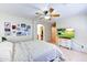 The bedroom features a ceiling fan, neutral walls, carpet, television, and a curated gallery wall of photos at 4379 E Rosemonte Dr, Phoenix, AZ 85050