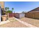 Outdoor back yard featuring a storage shed, palm trees, and a brick border at 5751 W Muriel Dr, Glendale, AZ 85308