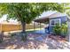 The backyard features a covered patio, a large shade tree, and low-maintenance gravel landscaping at 5751 W Muriel Dr, Glendale, AZ 85308