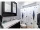 Cozy bathroom featuring a vanity with black cabinets, a toilet, and a shower with a starburst-patterned curtain at 5751 W Muriel Dr, Glendale, AZ 85308