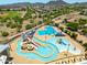 Aerial view of a community pool featuring slides, a lazy river, lap pool, and covered seating areas for residents to enjoy at 5751 W Muriel Dr, Glendale, AZ 85308