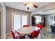 Bright dining area with sliding glass door and vintage-style red chairs around oval table at 5751 W Muriel Dr, Glendale, AZ 85308
