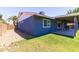 View of the home's exterior with covered patio, grassy lawn, and low-maintenance gravel landscaping at 5751 W Muriel Dr, Glendale, AZ 85308