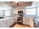 Contemporary kitchen featuring stainless steel appliances, granite counters and white cabinetry at 5751 W Muriel Dr, Glendale, AZ 85308