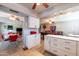 Bright kitchenette area with white cabinetry, granite countertops, and an adjacent game room at 5751 W Muriel Dr, Glendale, AZ 85308