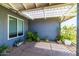 Outdoor patio area with a trellis, potted plants, and a window for natural light at 5751 W Muriel Dr, Glendale, AZ 85308