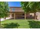 Expansive backyard featuring a covered patio, lush green lawn, and mature trees for shade at 6033 W Wood St, Phoenix, AZ 85043