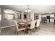 A well-lit dining area with a large wooden table, six chairs, and views into the kitchen and living area at 6033 W Wood St, Phoenix, AZ 85043