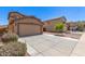 A cozy home with a spacious driveway and a small, well-kept tree in the front yard at 6033 W Wood St, Phoenix, AZ 85043