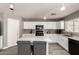 Bright kitchen with white cabinets and marble countertop island with seating at 6033 W Wood St, Phoenix, AZ 85043