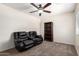 Comfortable living room with leather seating, ceiling fan, and built-in shelving for organization at 6033 W Wood St, Phoenix, AZ 85043