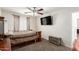 Main bedroom with ceiling fan, television, and chest at the end of the bed at 6033 W Wood St, Phoenix, AZ 85043