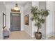 Bright entryway featuring neutral tile flooring, a decorative tree, and a paneled front door at 6135 E Campo Bello Dr, Scottsdale, AZ 85254