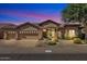 Single-story home featuring a three-car garage and well-manicured landscaping at 6135 E Campo Bello Dr, Scottsdale, AZ 85254