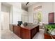 Well-lit home office with a large wooden desk, ample storage, and a serene view through plantation shutters at 6135 E Campo Bello Dr, Scottsdale, AZ 85254