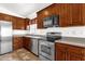 Well-lit kitchen featuring stainless steel appliances, granite countertops and wood cabinets at 6602 W Lariat Ln, Phoenix, AZ 85083