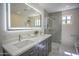 Contemporary bathroom with double sinks, illuminated mirror, and a glass-enclosed shower at 6608 E Ranch Rd, Cave Creek, AZ 85331