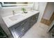 Bright bathroom featuring double sinks, under-cabinet lighting, marble floors and a glass shower at 6608 E Ranch Rd, Cave Creek, AZ 85331