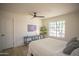 Bright bedroom featuring a ceiling fan, modern art, and a large window providing abundant natural light at 6608 E Ranch Rd, Cave Creek, AZ 85331