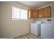 Bright laundry room featuring a window, cabinets, washer, and dryer at 6608 E Ranch Rd, Cave Creek, AZ 85331