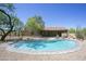 Backyard pool with rock and pebble surround and view of the house and patio at 6608 E Ranch Rd, Cave Creek, AZ 85331