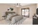 Cozy bedroom with a plush bed, modern decor, and a sliding glass door to the outside at 662 W Laguna Azul Ave, Mesa, AZ 85210