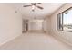 Bright living room featuring carpet floors, neutral walls, ceiling fan, and natural light at 662 W Laguna Azul Ave, Mesa, AZ 85210