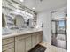 Well-lit bathroom featuring a dual-sink vanity with patterned wallpaper and a view to the main bedroom at 6803 E Main St # 5506, Scottsdale, AZ 85251