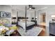 An elegant main bedroom featuring a four-poster bed, chair, and hardwood floors with a view to the walk-in closet at 6803 E Main St # 5506, Scottsdale, AZ 85251