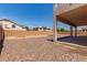 Large backyard features gravel landscaping, a covered patio, and block wall fencing for privacy at 7418 S 25Th Ln, Phoenix, AZ 85041