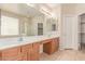 Spacious bathroom featuring dual sinks, a large mirror, tile flooring, and a separate glass-enclosed shower at 7418 S 25Th Ln, Phoenix, AZ 85041