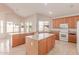 Bright kitchen with wooden cabinets, center island, and modern appliances, complemented by tile flooring at 7418 S 25Th Ln, Phoenix, AZ 85041